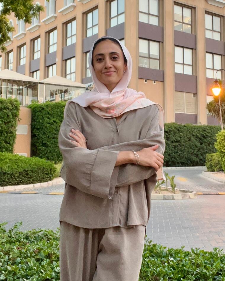 Farah Abdelbaki, founder of InJoy, smiling with arms crossed outside