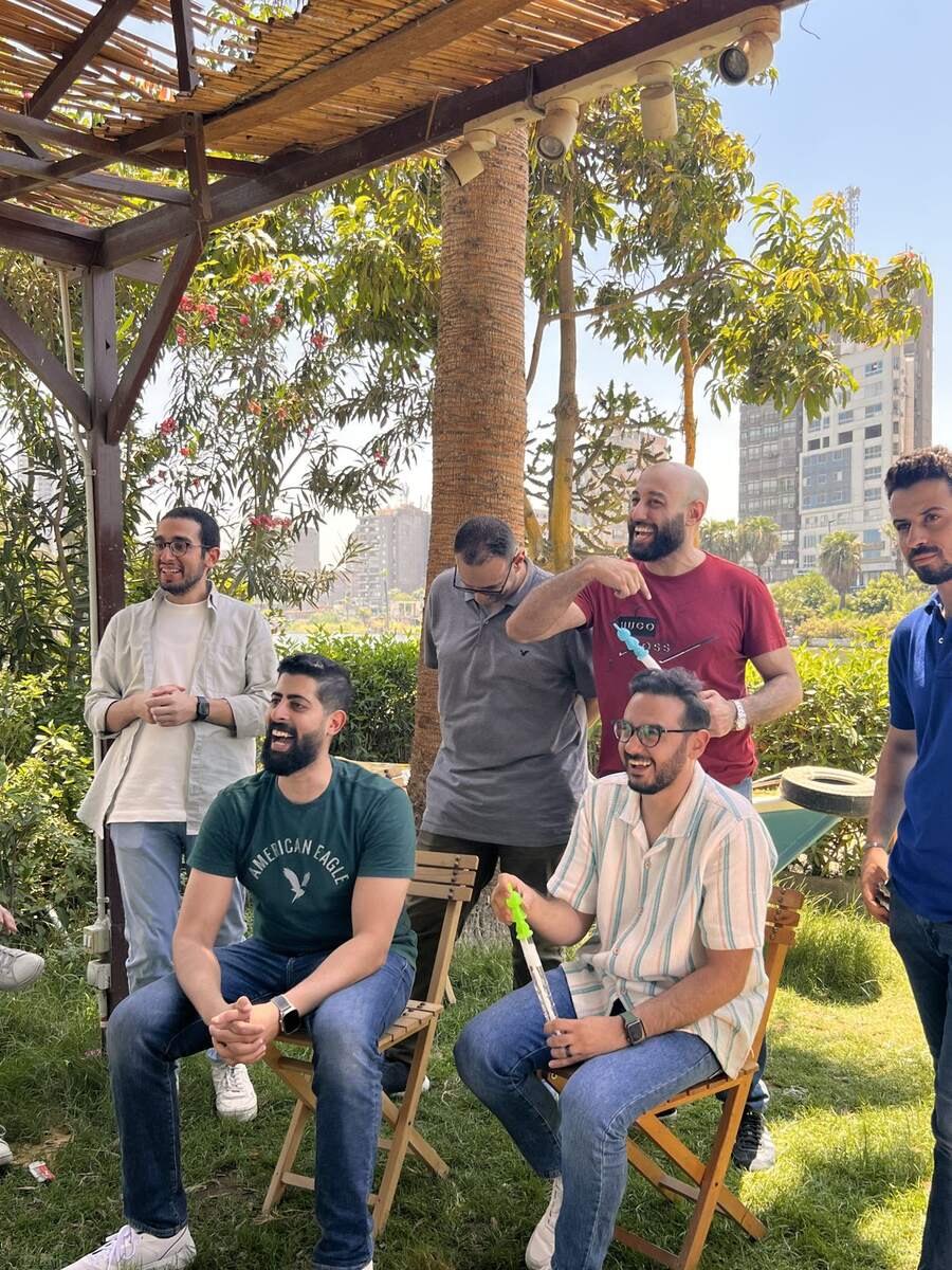 Team members laughing during a game, one holding a toy sword